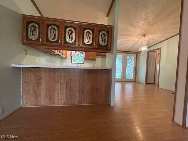 355 Muskingum River Rd, Marietta, OH 45750 - kitchen featuring light wood-style floors, a chandelier, a textured ceiling, light countertops, and a peninsula
