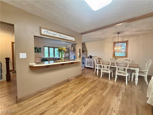 153 Lowes Dr, New Cumberland, WV 26047 - dining space featuring a textured ceiling, wood finished floors, and a chandelier