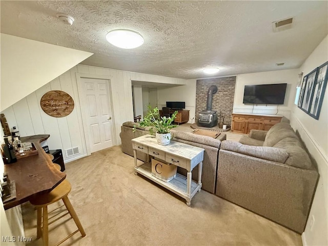 153 Lowes Dr, New Cumberland, WV 26047 - living area featuring a wood stove, light carpet, and a textured ceiling