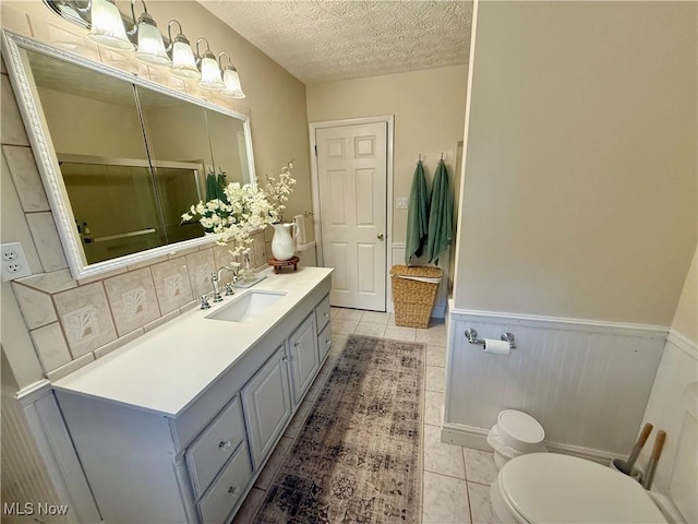 153 Lowes Dr, New Cumberland, WV 26047 - bathroom with vanity, tile patterned flooring, wainscoting, a textured ceiling, and backsplash