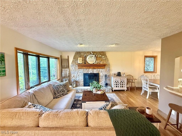 153 Lowes Dr, New Cumberland, WV 26047 - living area featuring wood finished floors, a textured ceiling, and a stone fireplace
