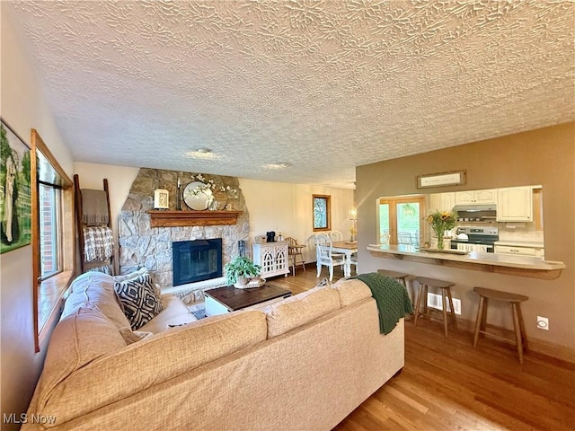 153 Lowes Dr, New Cumberland, WV 26047 - living area featuring light wood-type flooring, a stone fireplace, and a textured ceiling