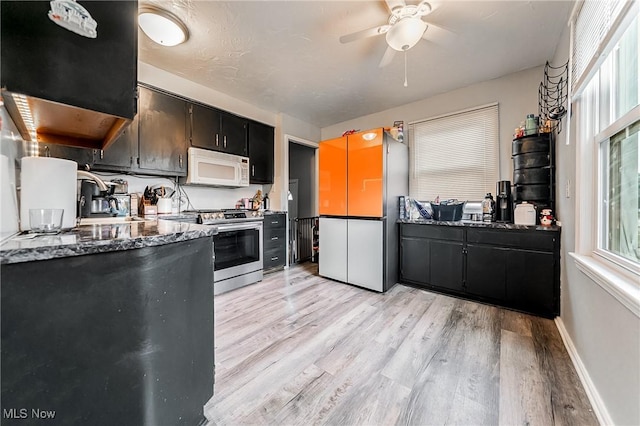 8006 Chesterfield Ave, Parma, OH 44129 - kitchen featuring electric stove, white microwave, light wood-style floors, dark cabinets, and ceiling fan