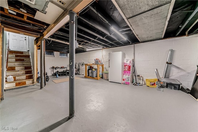 8006 Chesterfield Ave, Parma, OH 44129 - unfinished basement with stairway, freestanding refrigerator, and concrete block wall