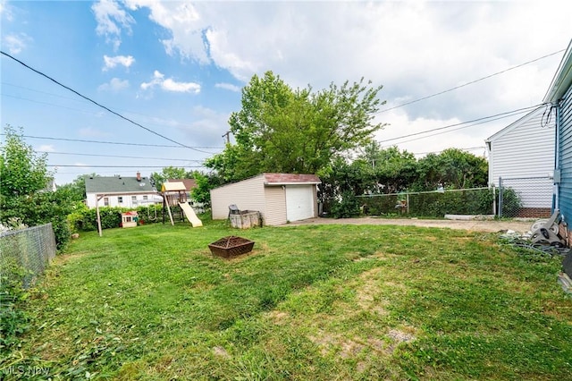 8006 Chesterfield Ave, Parma, OH 44129 - view of yard with an outdoor fire pit, driveway, a detached garage, and an outbuilding