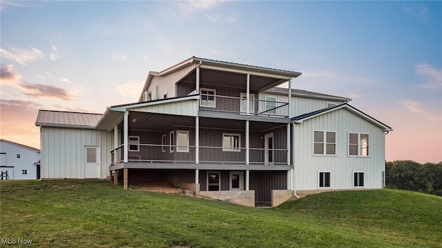 52110 Spencer Rd, Cumberland, OH 43732 - back of property at dusk with a yard, a balcony, and a metal roof