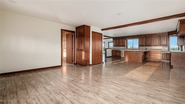 52110 Spencer Rd, Cumberland, OH 43732 - kitchen with light wood-style flooring, light countertops, open floor plan, beam ceiling, and tasteful backsplash