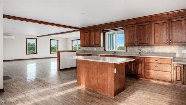52110 Spencer Rd, Cumberland, OH 43732 - kitchen with a kitchen island, decorative backsplash, light countertops, light wood-style flooring, and beam ceiling
