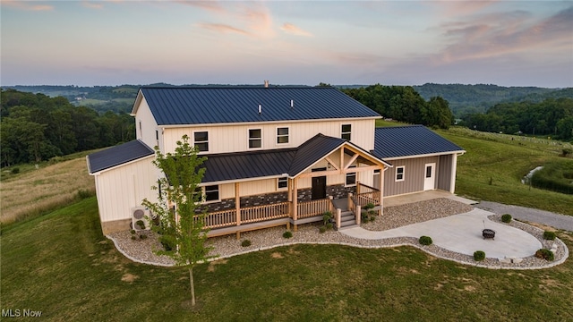 52110 Spencer Rd, Cumberland, OH 43732 - back of house with a fire pit, a lawn, driveway, and a metal roof