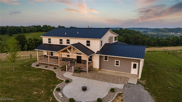 52110 Spencer Rd, Cumberland, OH 43732 - back of property at dusk featuring a lawn, a metal roof, and board and batten siding