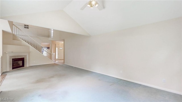 8531 Creekside Dr, Sagamore Hills, OH 44067 - unfurnished living room featuring a ceiling fan, carpet floors, stairs, a tiled fireplace, and high vaulted ceiling