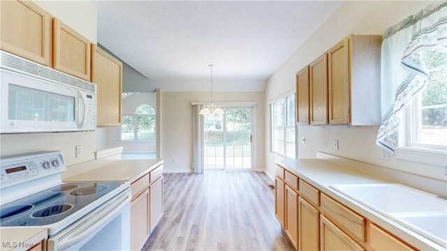 8531 Creekside Dr, Sagamore Hills, OH 44067 - kitchen featuring white appliances, a chandelier, light wood-type flooring, light countertops, and vaulted ceiling