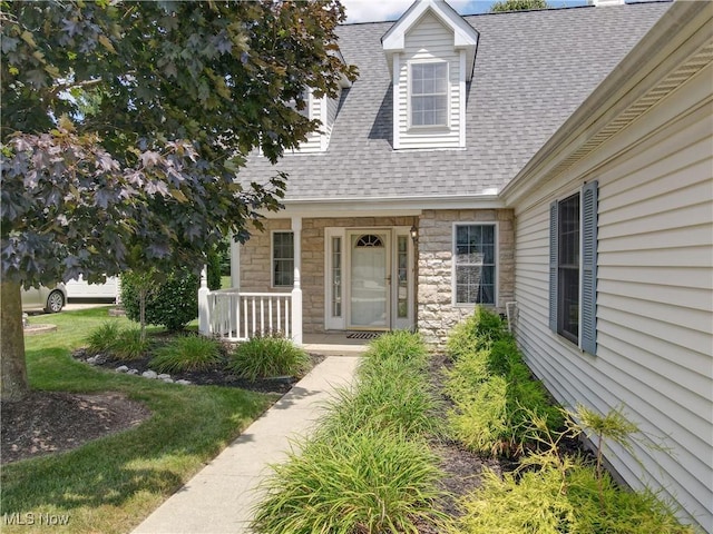 8531 Creekside Dr, Sagamore Hills, OH 44067 - property entrance featuring roof with shingles, stone siding, and a porch