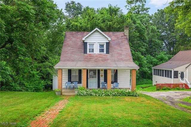 192 Swartz Rd, Akron, OH 44319 - cape cod house with a porch, a front lawn, a chimney, and brick siding