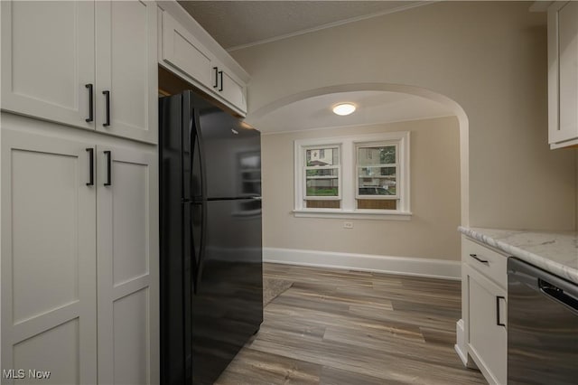 41 New St, Barberton, OH 44203 - kitchen with freestanding refrigerator, dishwashing machine, light wood finished floors, white cabinetry, and light stone countertops