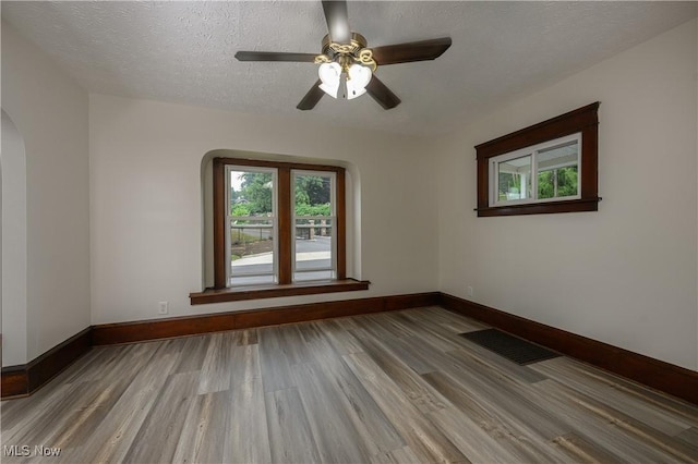 41 New St, Barberton, OH 44203 - empty room featuring arched walkways, wood finished floors, ceiling fan, and a textured ceiling