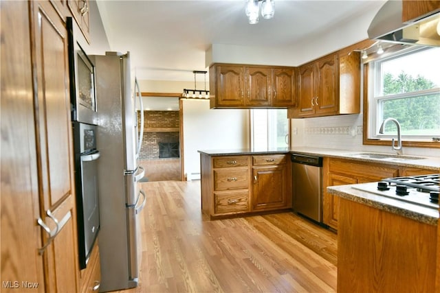 2153 Stillwagon Rd SE, Warren, OH 44484 - kitchen featuring brown cabinetry, a peninsula, light wood finished floors, and appliances with stainless steel finishes