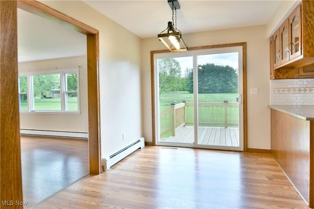 2153 Stillwagon Rd SE, Warren, OH 44484 - unfurnished dining area with a baseboard heating unit and light wood-type flooring