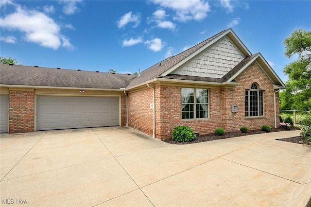 1137 Saint Abigail St SW, Hartville, OH 44632 - view of front of house with concrete driveway, a shingled roof, a garage, and brick siding