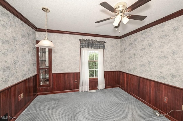 1137 Saint Abigail St SW, Hartville, OH 44632 - carpeted spare room with wainscoting, crown molding, ceiling fan, wooden walls, and wallpapered walls