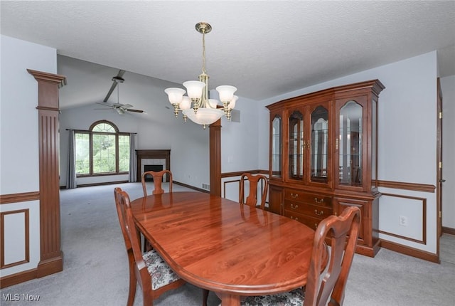 1137 Saint Abigail St SW, Hartville, OH 44632 - dining space featuring light colored carpet, a chandelier, a ceiling fan, vaulted ceiling, and a tiled fireplace