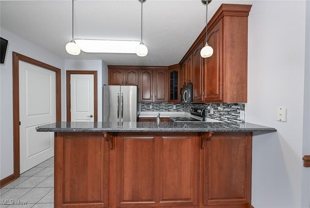 1137 Saint Abigail St SW, Hartville, OH 44632 - kitchen featuring dark stone countertops, a peninsula, glass insert cabinets, stainless steel appliances, and backsplash