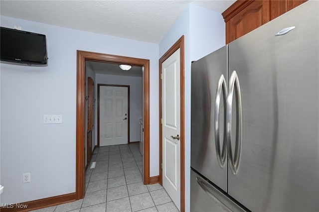 1137 Saint Abigail St SW, Hartville, OH 44632 - kitchen with freestanding refrigerator, light tile patterned floors, and brown cabinetry