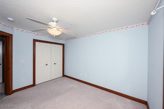 1137 Saint Abigail St SW, Hartville, OH 44632 - unfurnished bedroom featuring a closet, carpet, ceiling fan, and a textured ceiling