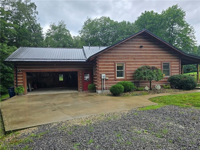 48820 Hillcrest Dr, Caldwell, OH 43724 - cabin featuring concrete driveway, a metal roof, an attached garage, and log exterior