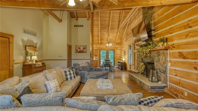 48820 Hillcrest Dr, Caldwell, OH 43724 - living area featuring high vaulted ceiling, wood finished floors, french doors, a stone fireplace, and a wood ceiling with exposed beams