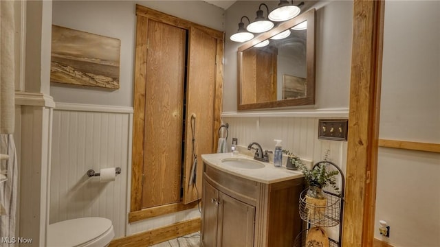 48820 Hillcrest Dr, Caldwell, OH 43724 - half bath featuring wainscoting, vanity, and wood finished floors