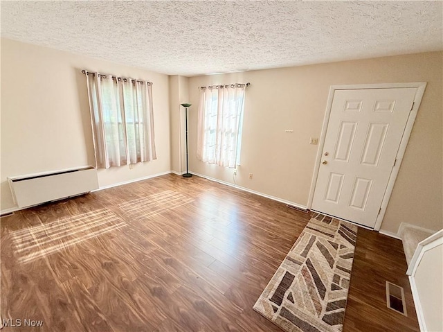 1489 Munroe Falls Ave, Cuyahoga Falls, OH 44221 - entrance foyer with wood finished floors, a textured ceiling, and a baseboard heating unit