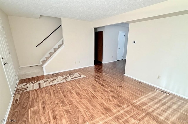 1489 Munroe Falls Ave, Cuyahoga Falls, OH 44221 - spare room featuring stairs, a textured ceiling, and wood finished floors