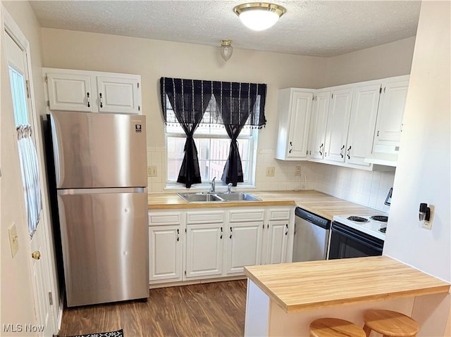 1489 Munroe Falls Ave, Cuyahoga Falls, OH 44221 - kitchen with appliances with stainless steel finishes, dark wood-style floors, white cabinets, backsplash, and a textured ceiling