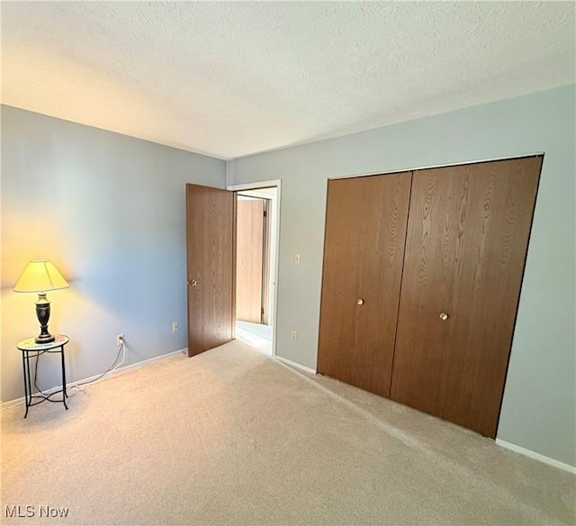 1489 Munroe Falls Ave, Cuyahoga Falls, OH 44221 - unfurnished bedroom featuring carpet flooring, a textured ceiling, and a closet
