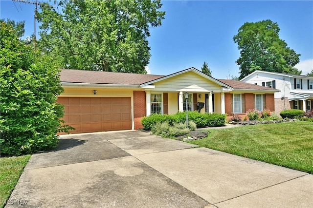 2741 Citadel Dr NE, Warren, OH 44483 - ranch-style home featuring brick siding, concrete driveway, an attached garage, and a front lawn