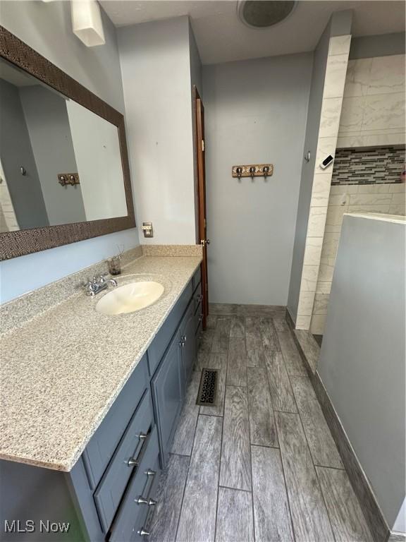 6279 Palmer Dr NW, Canton, OH 44718 - full bath with wood finished floors, vanity, and a tile shower