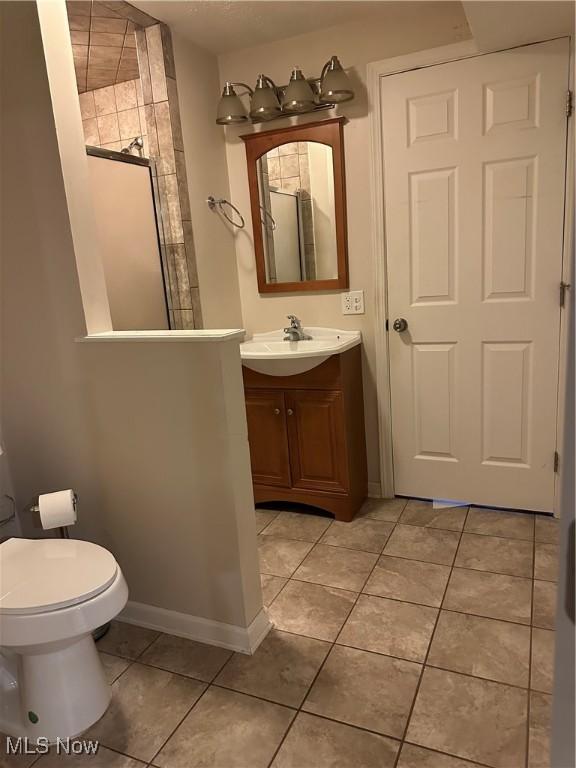 6279 Palmer Dr NW, Canton, OH 44718 - bathroom featuring vanity, tile patterned flooring, and walk in shower