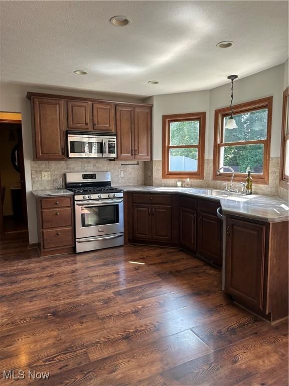 6279 Palmer Dr NW, Canton, OH 44718 - kitchen featuring appliances with stainless steel finishes, dark wood-style floors, tasteful backsplash, decorative light fixtures, and recessed lighting