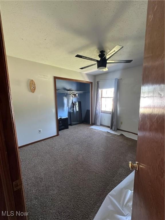 6279 Palmer Dr NW, Canton, OH 44718 - unfurnished living room with a textured ceiling, carpet floors, and ceiling fan