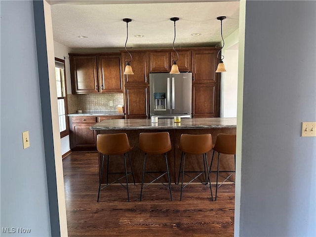 6279 Palmer Dr NW, Canton, OH 44718 - kitchen featuring stainless steel fridge with ice dispenser, dark wood-style flooring, backsplash, a kitchen breakfast bar, and decorative light fixtures