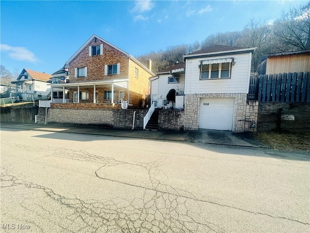 668 Virginia Ave, Follansbee, WV 26037 - view of front of property with an attached garage, stone siding, and concrete driveway