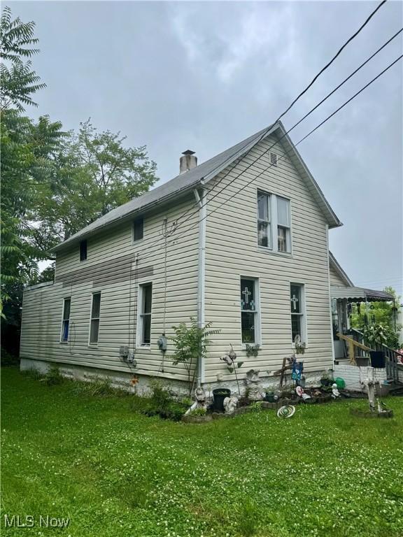 526 Madison Ave, Akron, OH 44320 - rear view of house with a lawn and a chimney