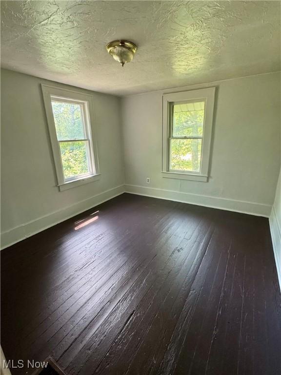 348 Jewell Dr, Akron, OH 44311 - unfurnished room featuring dark wood finished floors, plenty of natural light, and a textured ceiling