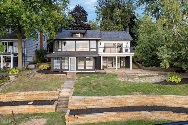 3350 S Main St, Akron, OH 44319 - rear view of property featuring a lawn, a patio area, a chimney, a shingled roof, and a sunroom