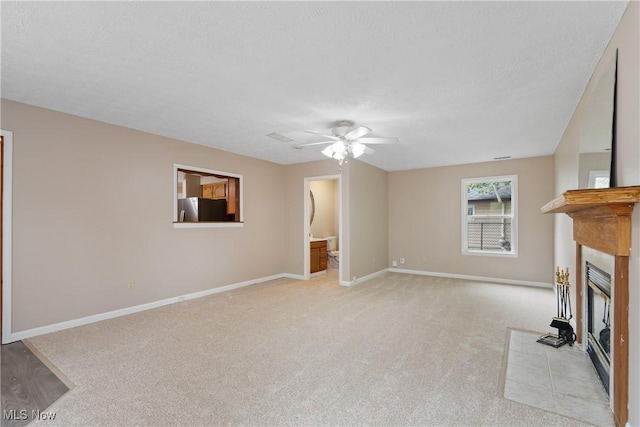 3139 Prior Dr, Cuyahoga Falls, OH 44223 - unfurnished living room with light carpet, a tile fireplace, ceiling fan, and a textured ceiling