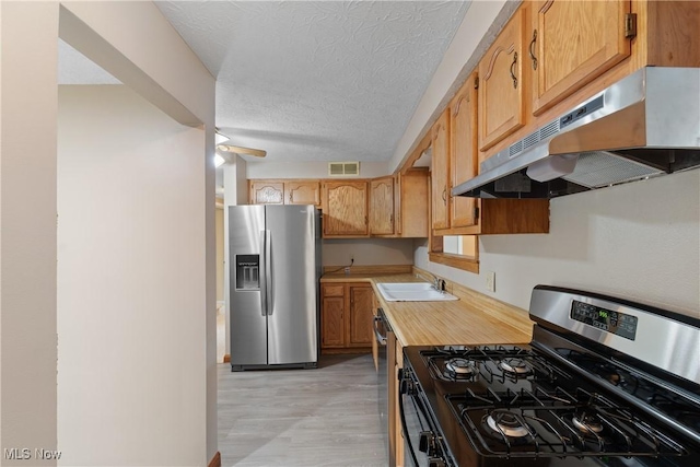 3139 Prior Dr, Cuyahoga Falls, OH 44223 - kitchen with stainless steel appliances, light countertops, under cabinet range hood, a textured ceiling, and light flooring