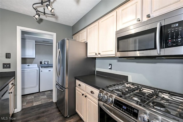 8714 Quailridge Ct, Macedonia, OH 44056 - kitchen with separate washer and dryer, appliances with stainless steel finishes, dark countertops, a textured ceiling, and dark wood-style floors
