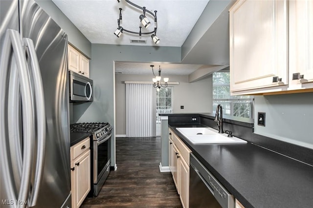 8714 Quailridge Ct, Macedonia, OH 44056 - kitchen featuring stainless steel appliances, dark countertops, dark wood finished floors, a chandelier, and cream cabinetry