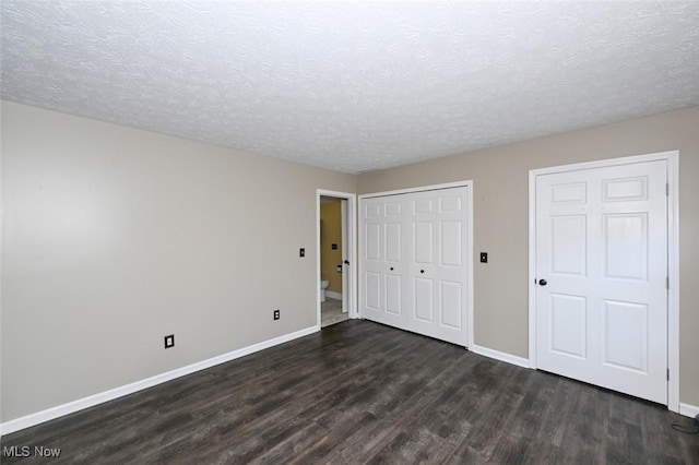 8714 Quailridge Ct, Macedonia, OH 44056 - unfurnished bedroom with dark wood-style floors, a textured ceiling, and a closet
